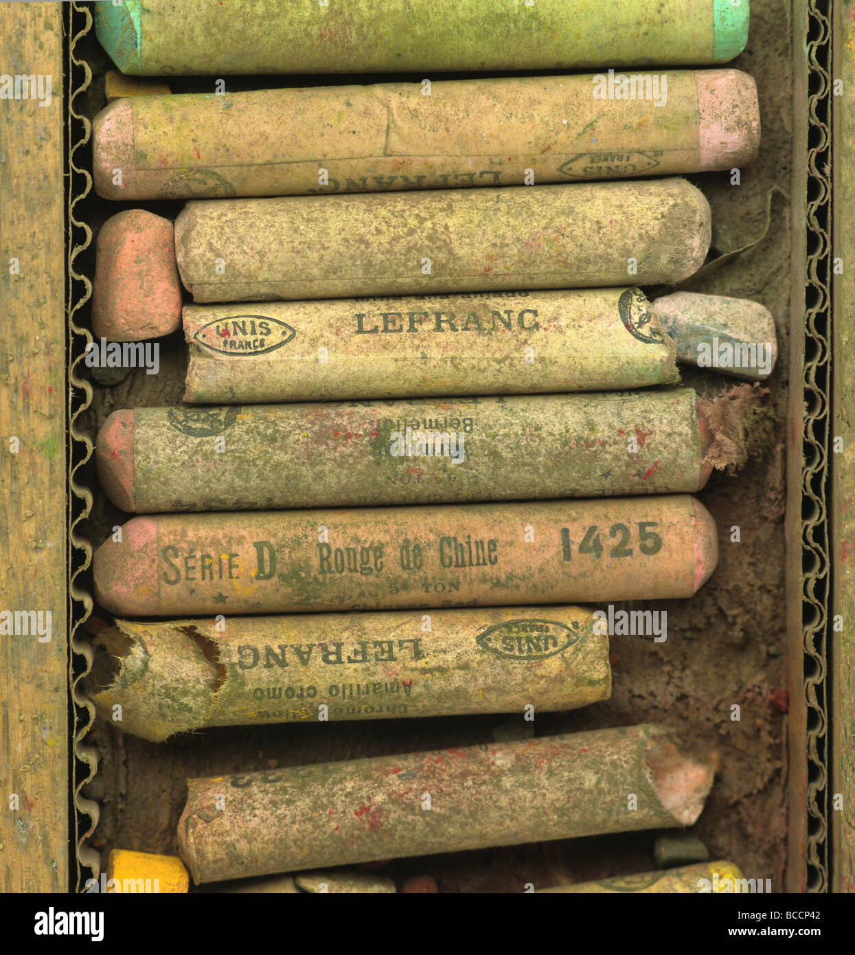 Collezione di vibranti pastelli di gesso in una scatola di legno disposta per colore e dimensioni nello spazio di lavoro di un artista Foto Stock