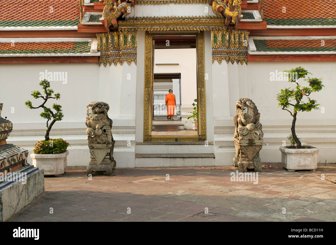 Un monaco buddista solitario che cammina attraverso le porte di Wat Pho Bangkok Thailandia Foto Stock