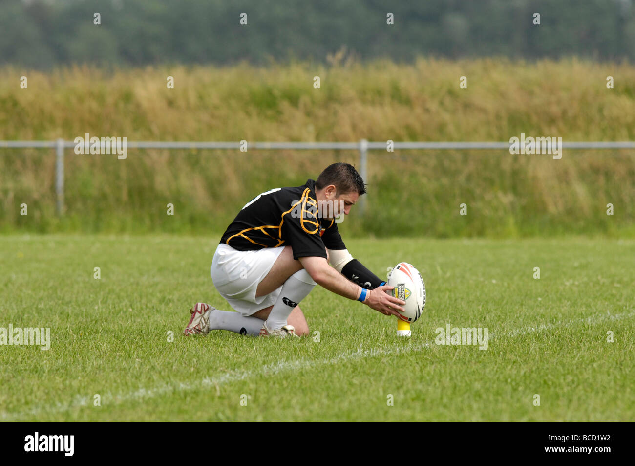 Giocatore di rugby posizionare con cautela la palla prima di tentare una conversione Foto Stock