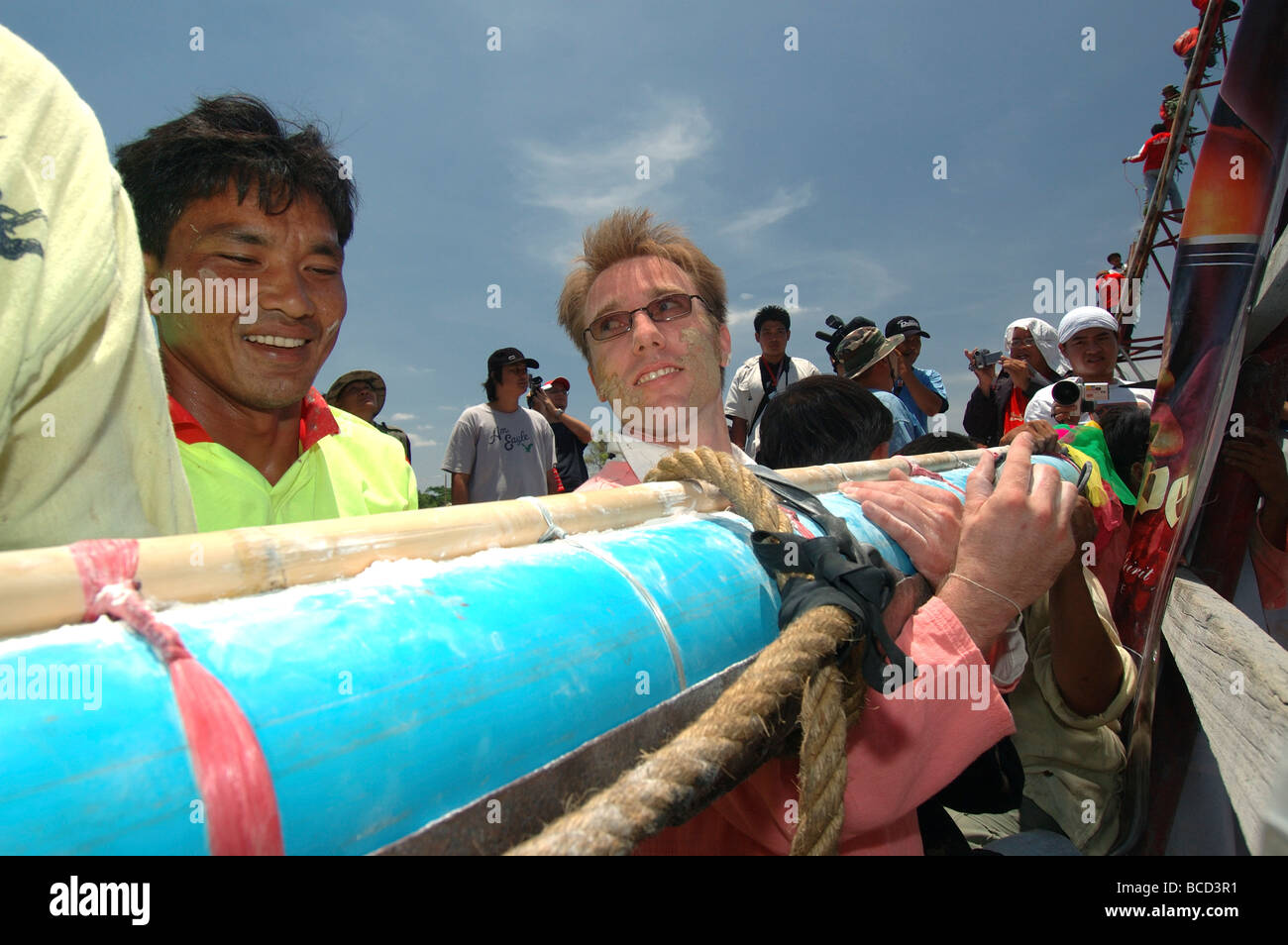 Chiedere l'uomo dalla Norvegia aiuta la sua squadra alzare la loro razzo sul lancio di stand presso il Festival a razzo in Yasothon thailandi Foto Stock