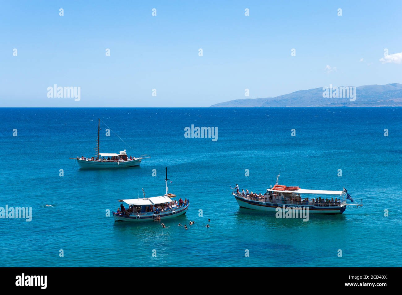 Escursione barche ormeggiato a una spiaggia appena fuori Hersonissos, costa nord di Creta, Grecia Foto Stock