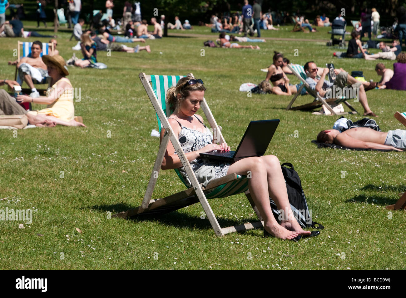 Donna al lavoro su computer portatile in St James Park Londra Inghilterra REGNO UNITO Foto Stock