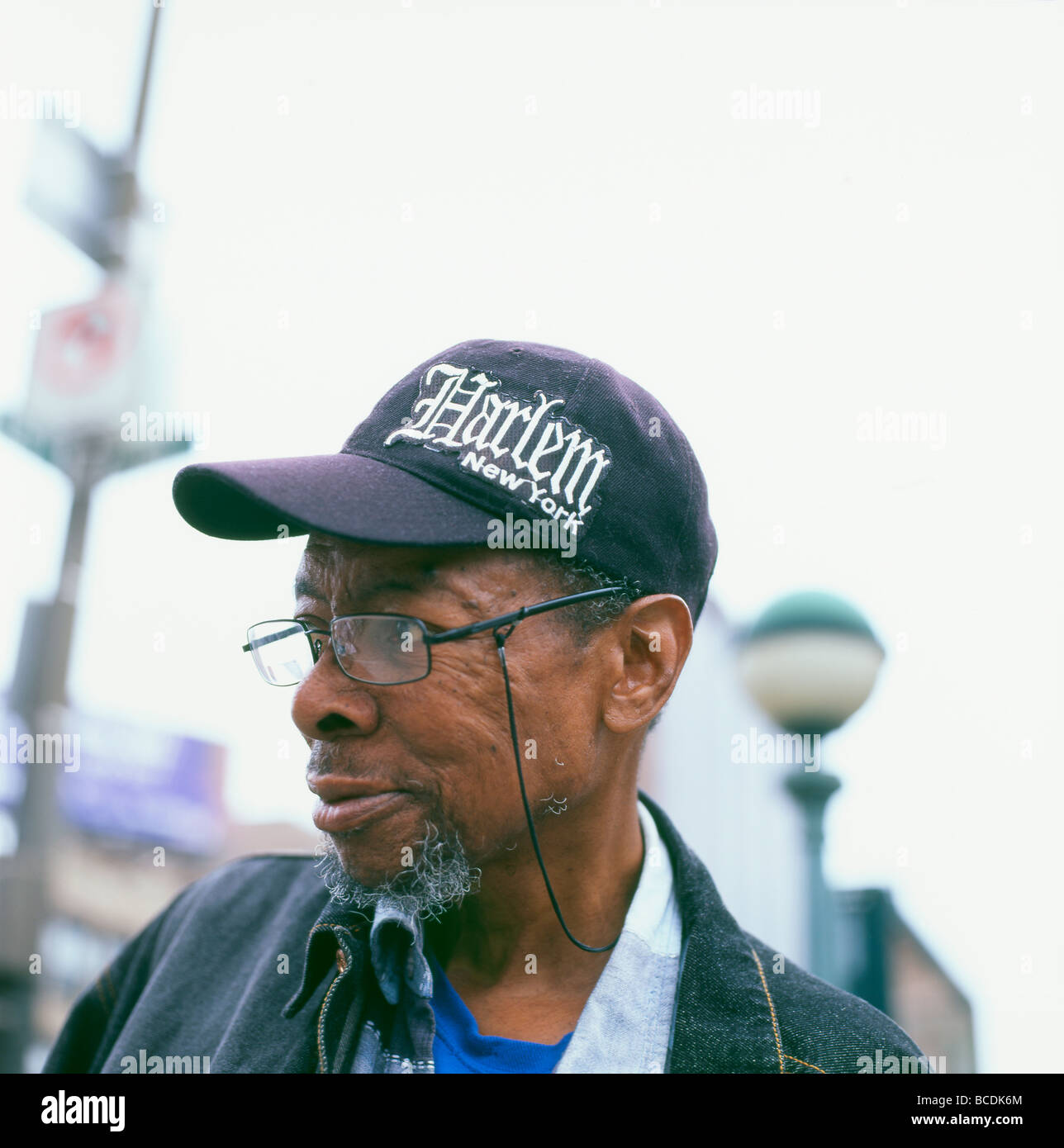Un anziano Afro American uomo che indossa un cappello da baseball con il testo Harlem New York STATI UNITI D'AMERICA KATHY DEWITT Foto Stock