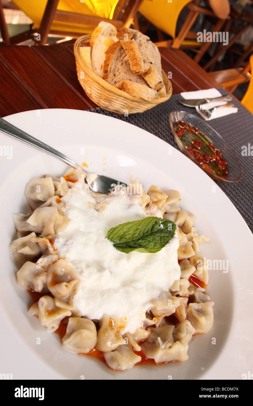 La Turchia cibo turco una piastra di manti di piccole parcelle di pasta ripiene di carne di agnello macinata in una salsa di aglio servita con yogurt e menta Foto Stock