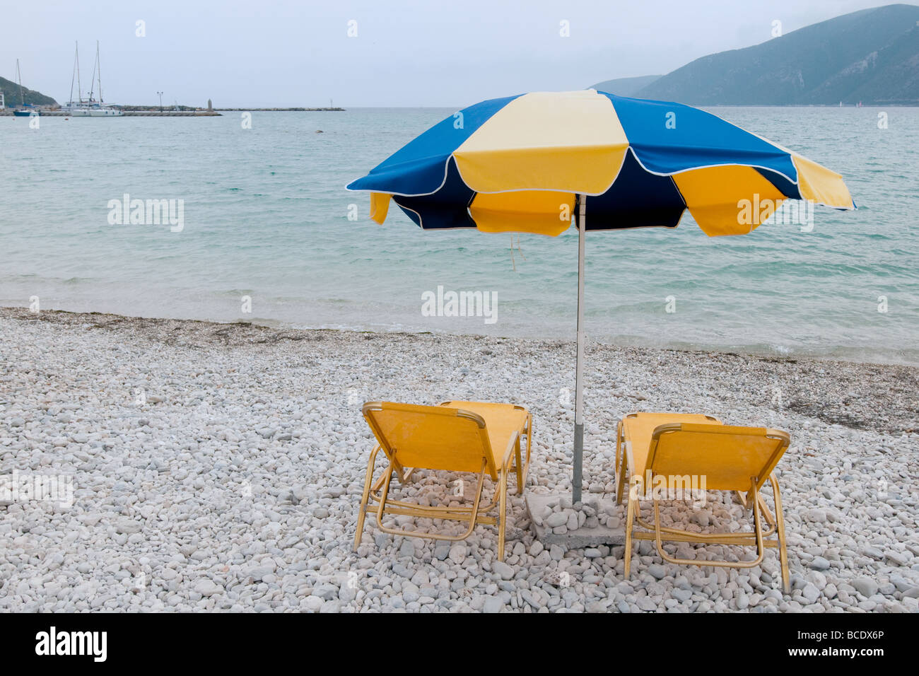 Il blu e il giallo ombrellone in spiaggia Foto stock - Alamy