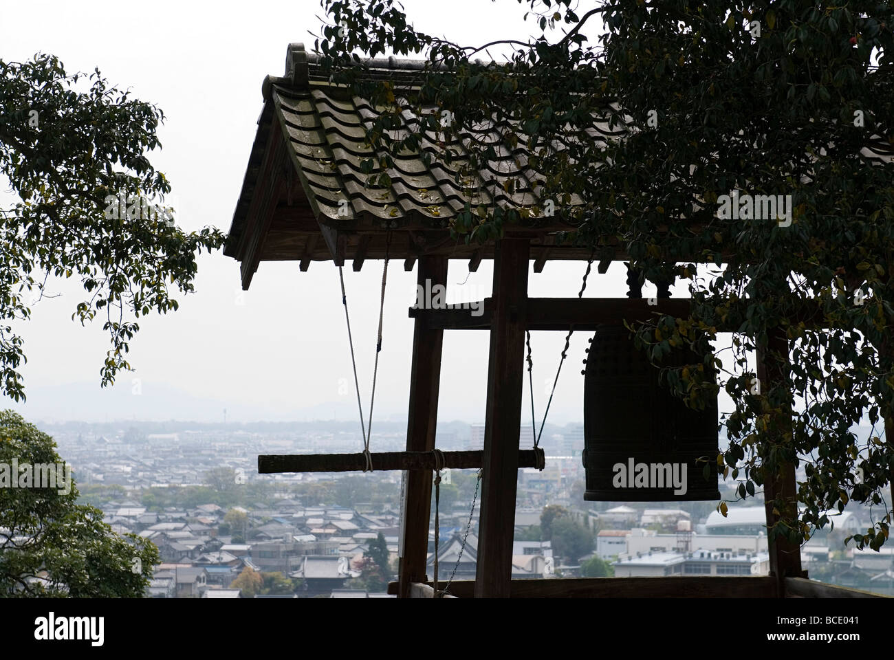 Una silhouette di un tempio giapponese campana al castello di Hikone con lo skyline della città e orizzonte in background Foto Stock
