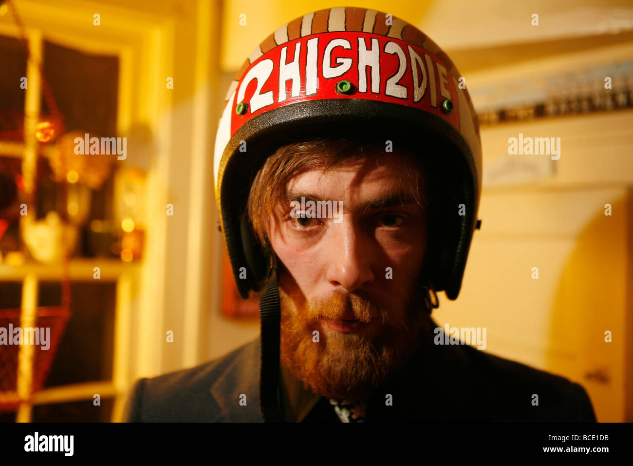 Un uomo che indossa un casco con le parole, 2 Alta 2 muore", scritto in vernice durante una festa. Foto Stock