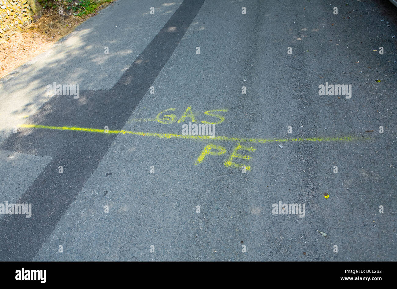Vernice gialla su strada che indica dove sarà posato il tubo del gas (vernice gialla indica tutte le cose da fare con il gas) Regno Unito Foto Stock