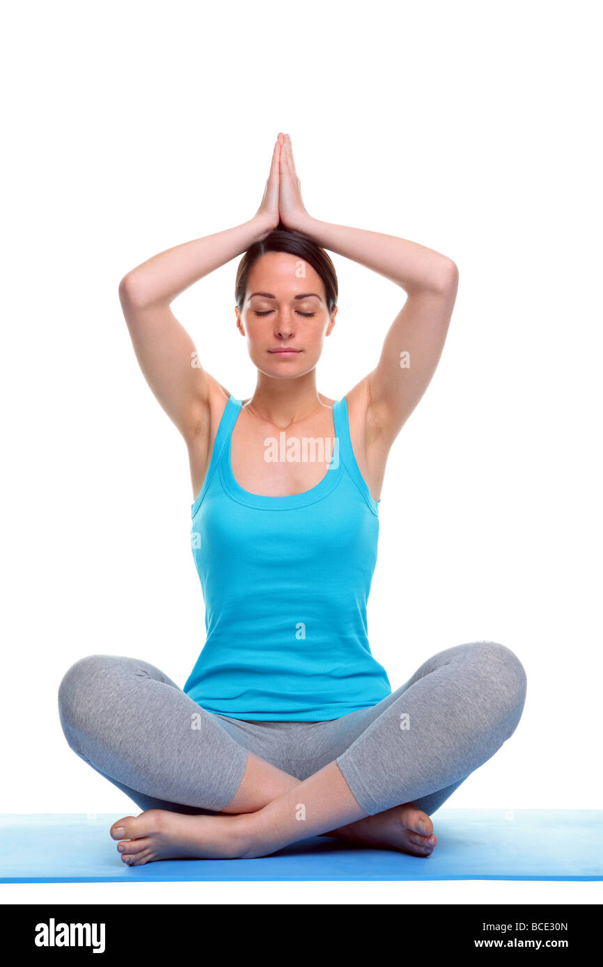 Donna sat in una posizione di yoga meditazione isolati su sfondo bianco Foto Stock