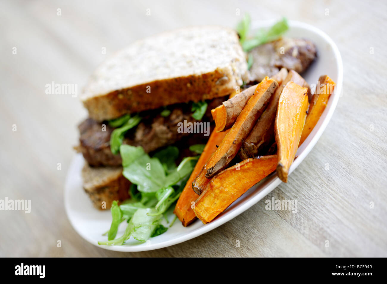 Carni bovine fresche steak sandwich seminate in crosta di pane scuro di farina integrale con un contorno di insalata e nessun popolo Foto Stock