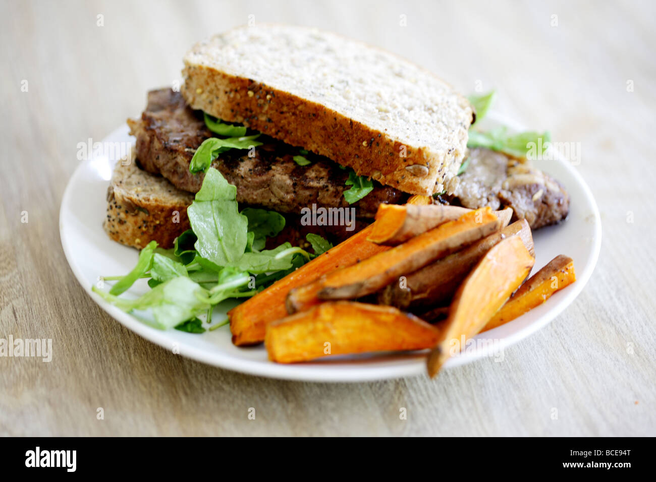 Carni bovine fresche steak sandwich seminate in crosta di pane scuro di farina integrale con un contorno di insalata e nessun popolo Foto Stock