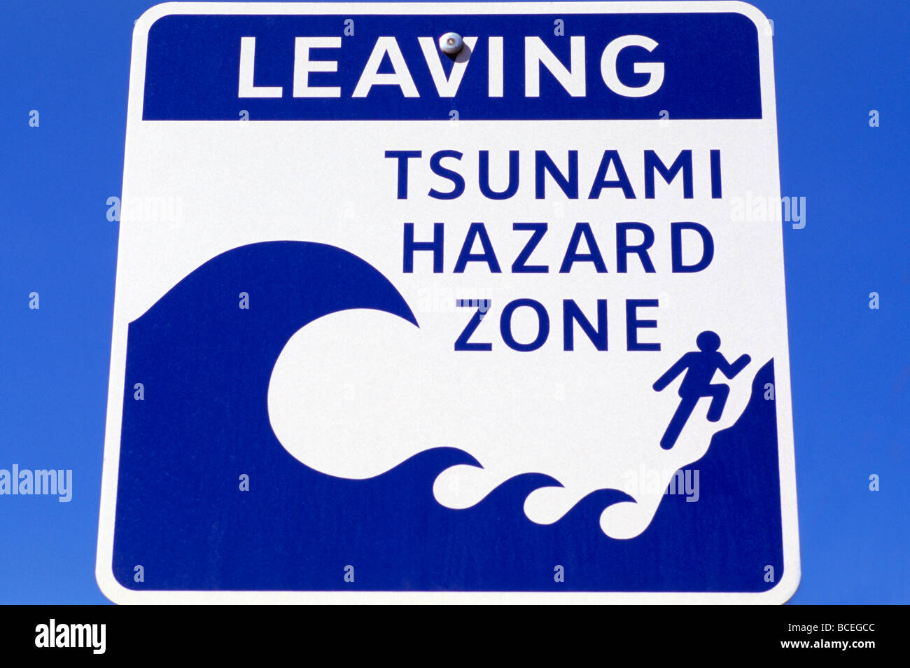 Lasciando Tsunami zona di pericolo i percorsi di evacuazione autostrada cartello stradale Foto Stock