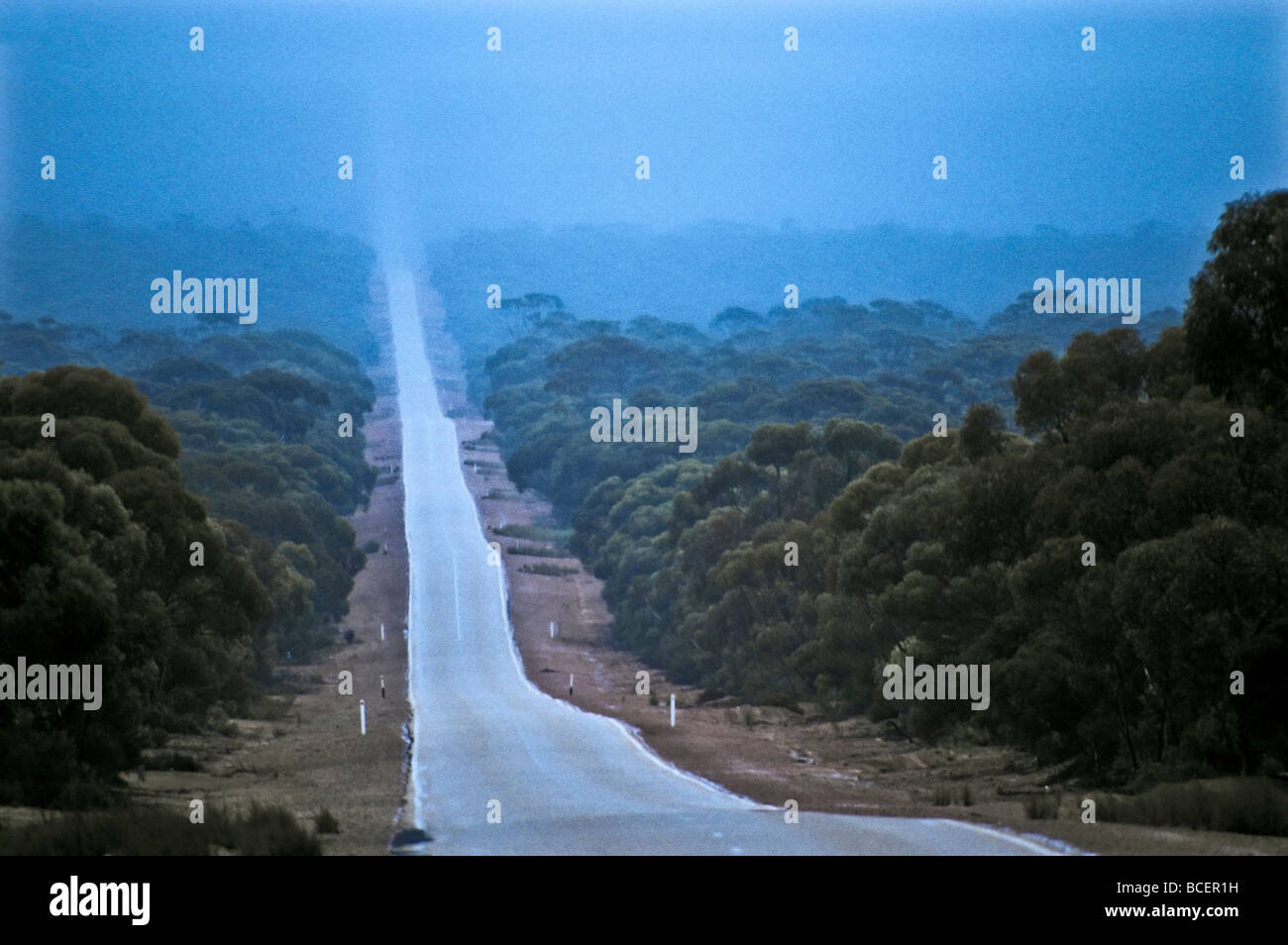 Una tempesta di pioggia cade su una lunga strada diritta sul Nullarbor Plain. Foto Stock