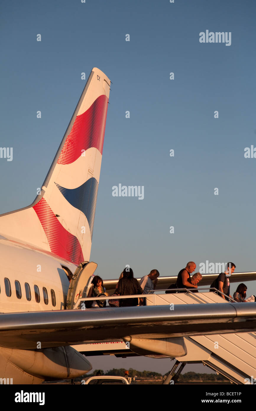 I passeggeri di sbarco da un British Airways aereo al tramonto, Malta Foto Stock