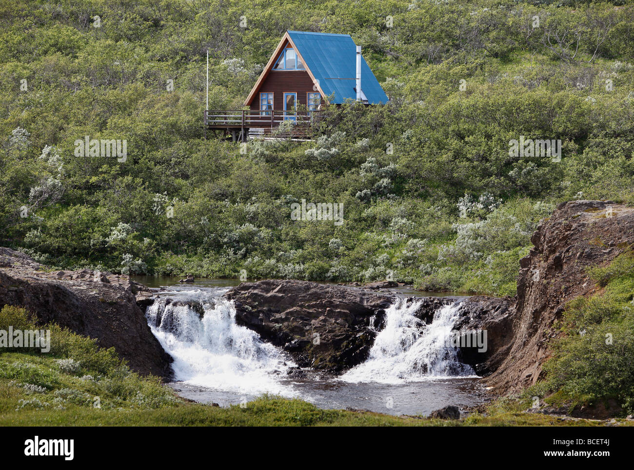 Un telaio a casa di vacanza da una cascata nel nord-est dell'Islanda Foto Stock