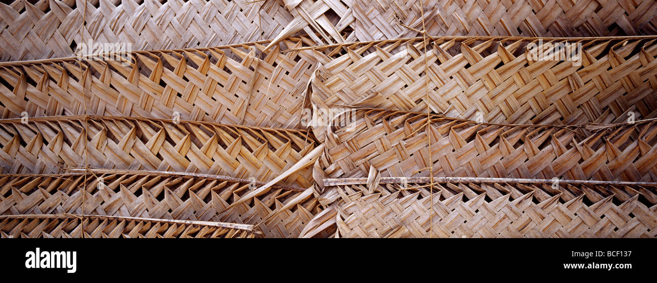 Un semplice tappeto di tessuto di fronde di palma creare una parete per un capanno sulla spiaggia. Foto Stock