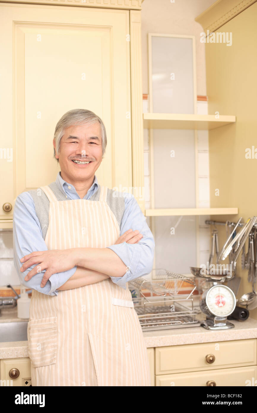 Senior man standing in cucina Foto Stock