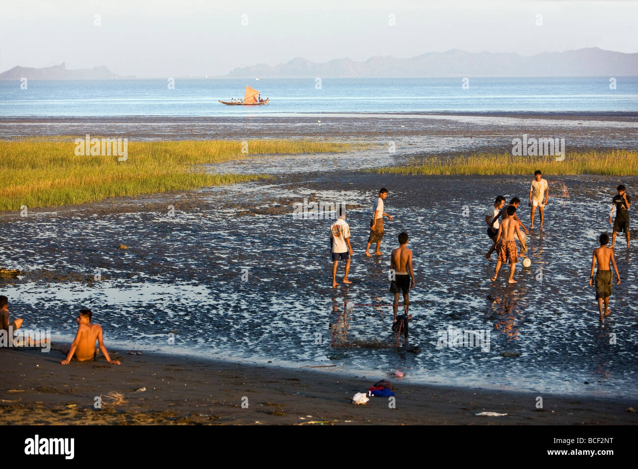 Myanmar Birmania, Stato di Rakhine. Nel tardo pomeriggio, ragazzi giocare a calcio su uno di Sittwe s spiagge di marea. Foto Stock