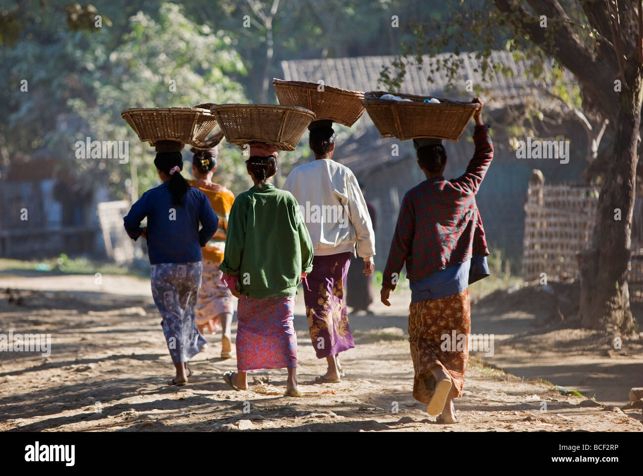Myanmar Birmania Mrauk U. Rakhine donne ritorno da Mrauk U mercato con tessuto cesti di bambù sulle loro teste. Foto Stock
