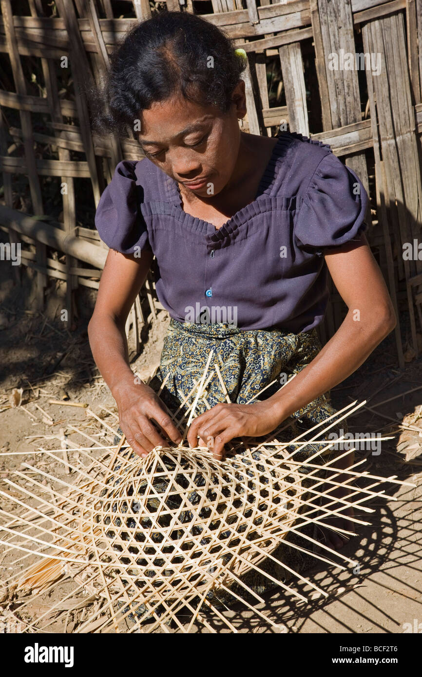Myanmar Birmania Mrauk U. Una donna abilmente rende la cornice di bambù di una conica, largo-colmato hat. Foto Stock