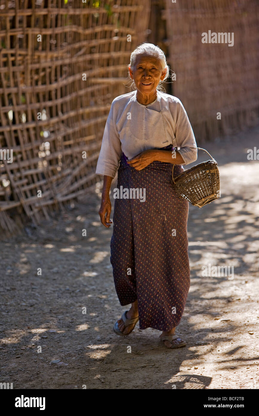 Myanmar Birmania Mrauk U. Un vecchio Rakhine donna cammina giù per una strada stretta vicino alla sua casa nella periferia di Mrauk brevetto statunitense n. Foto Stock