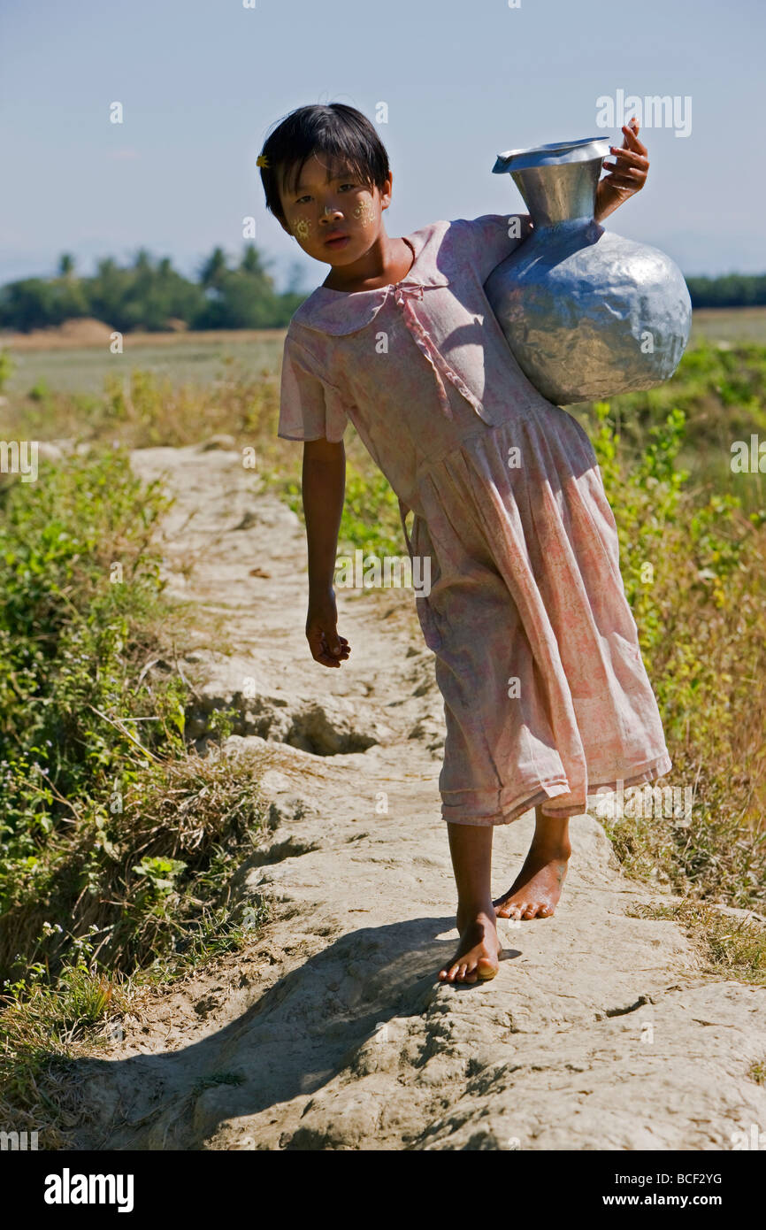 Myanmar Birmania, Stato di Rakhine, Laung Shein. Una giovane ragazza di Laung Shein village raccoglie acqua da una vicina diga. Foto Stock