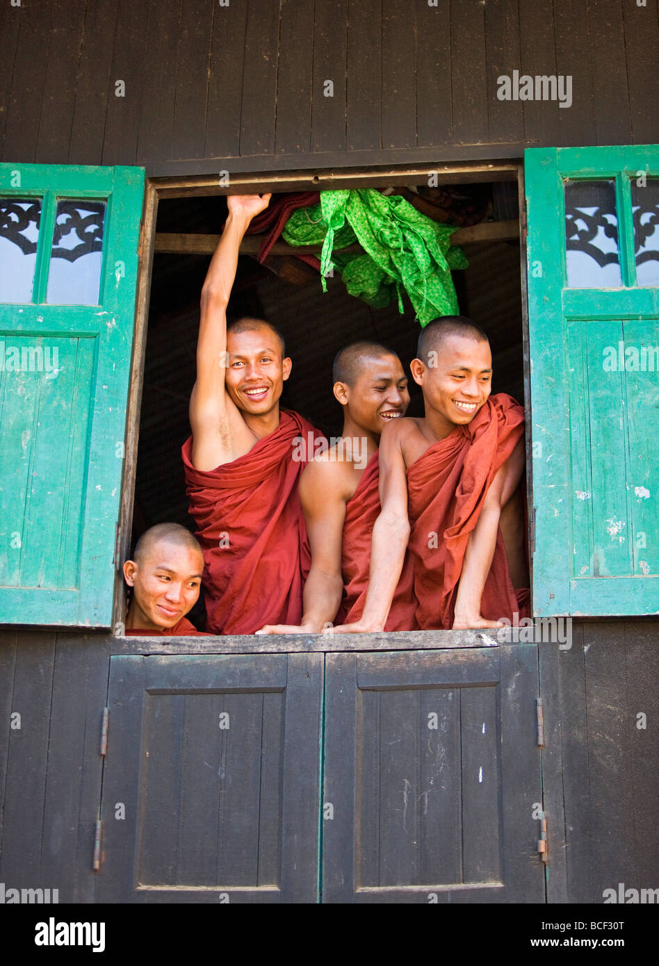 Myanmar Birmania, Stato di Rakhine, Sittwe. Allegro novizio monaci guardare al di fuori della loro finestra del dormitorio presso il monastero Pathain. Foto Stock