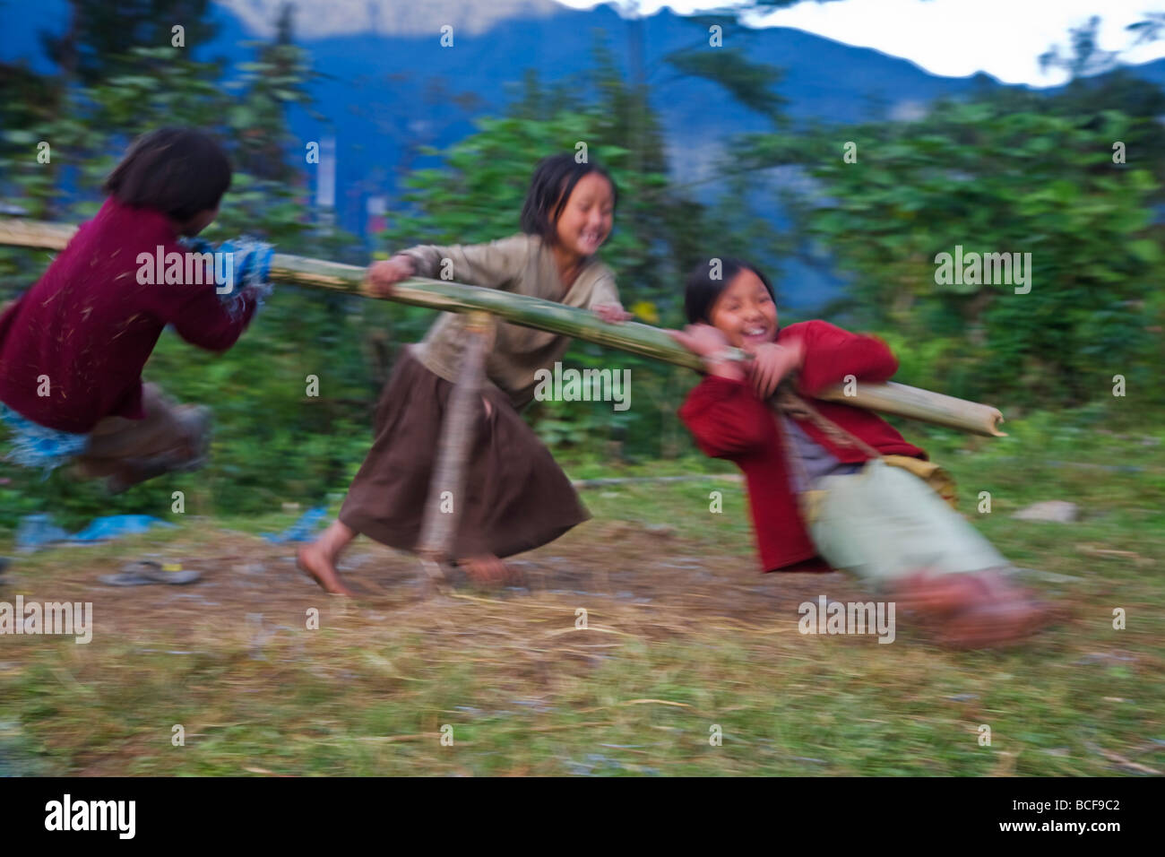 India, Sikkim, Khecheopalri Lake, bambini che giocano sulla rotatoria di bambù Foto Stock