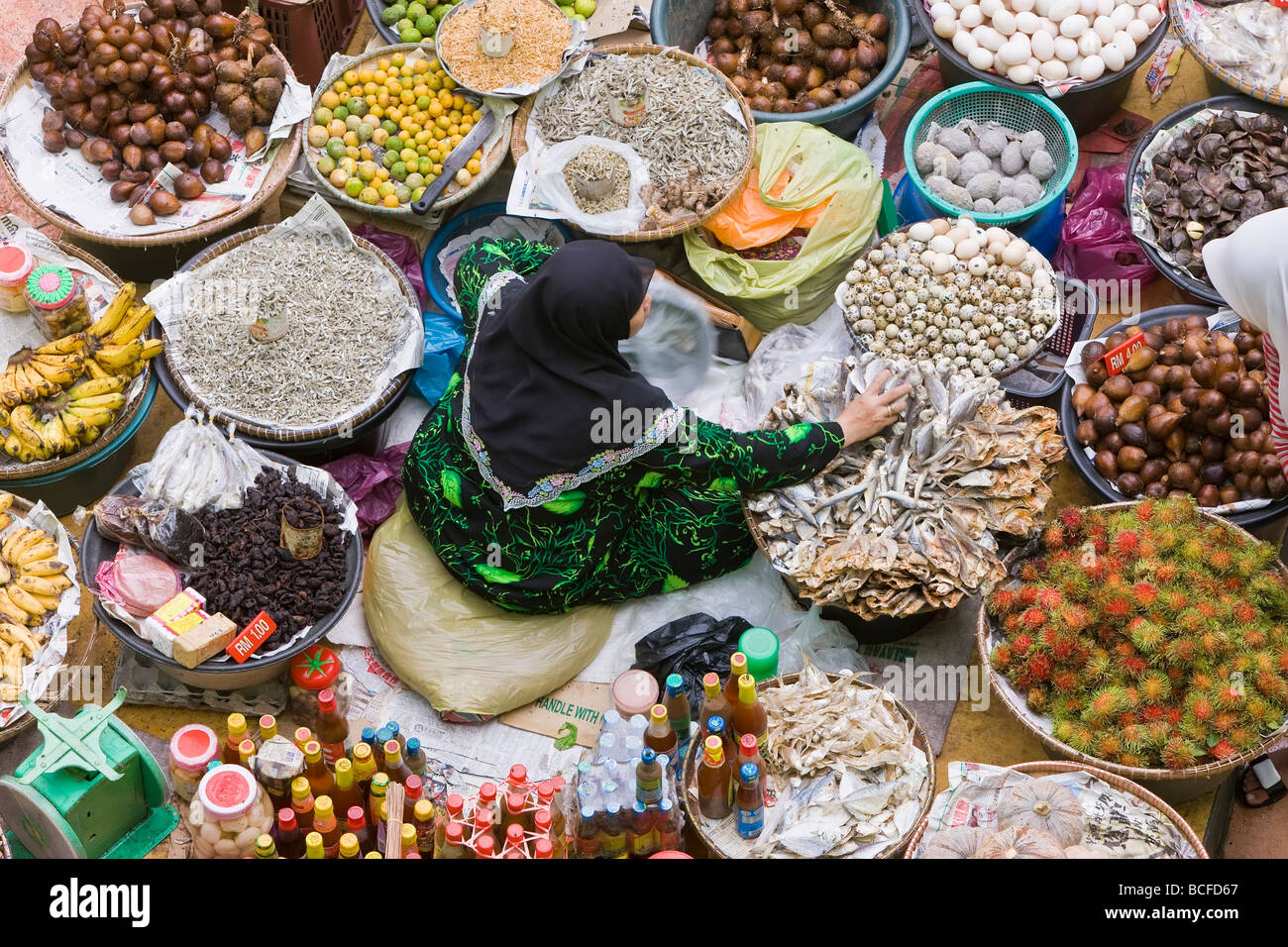 Malaysia, Kelantan Stato, Kota Bharu, mercato centrale, donna per la vendita di frutta e verdura Foto Stock