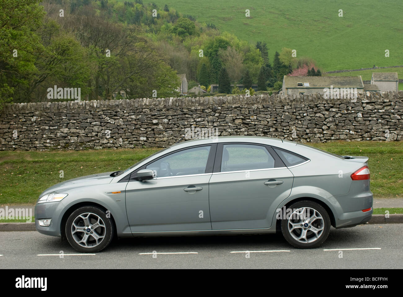 Vista laterale di una Ford Mondeo berlina di titanio auto parcheggiate a lato della strada nelle zone rurali del Derbyshire Inghilterra Foto Stock