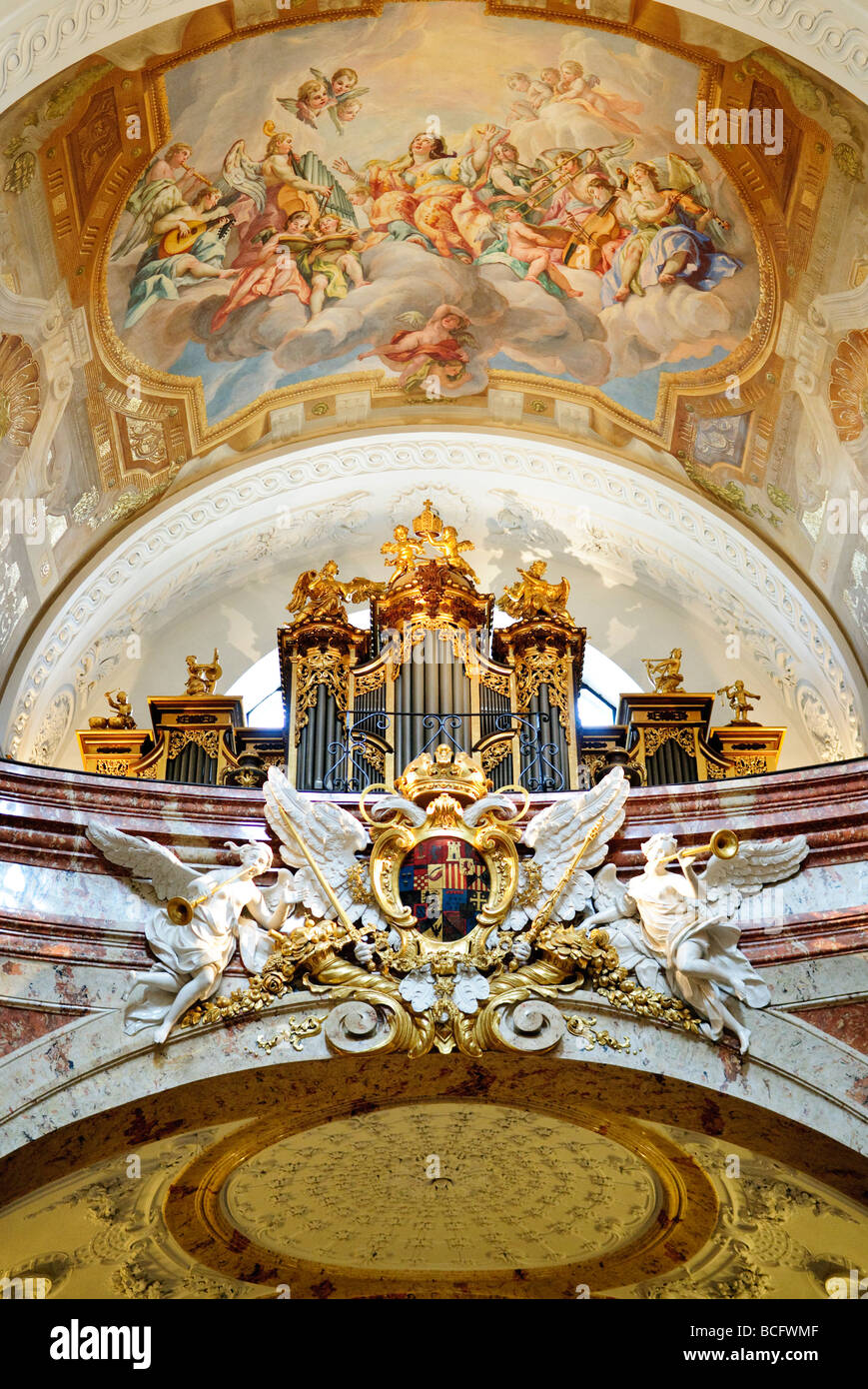 VIENNA, Austria — parte dell'organo a tubo e soffitto ornato a Karlskirche a Vienna. Karlskirche, o St. La chiesa di Carlo, si erge alto contro lo skyline viennese con la sua distinta cupola verde e due colonne fiancheggianti. La chiesa, opera esemplare di architettura barocca, fu costruita all'inizio del 18th ed è dedicata a San Carlo Borromeo, figura nota per la sua dedizione ai malati durante il periodo della peste. Foto Stock