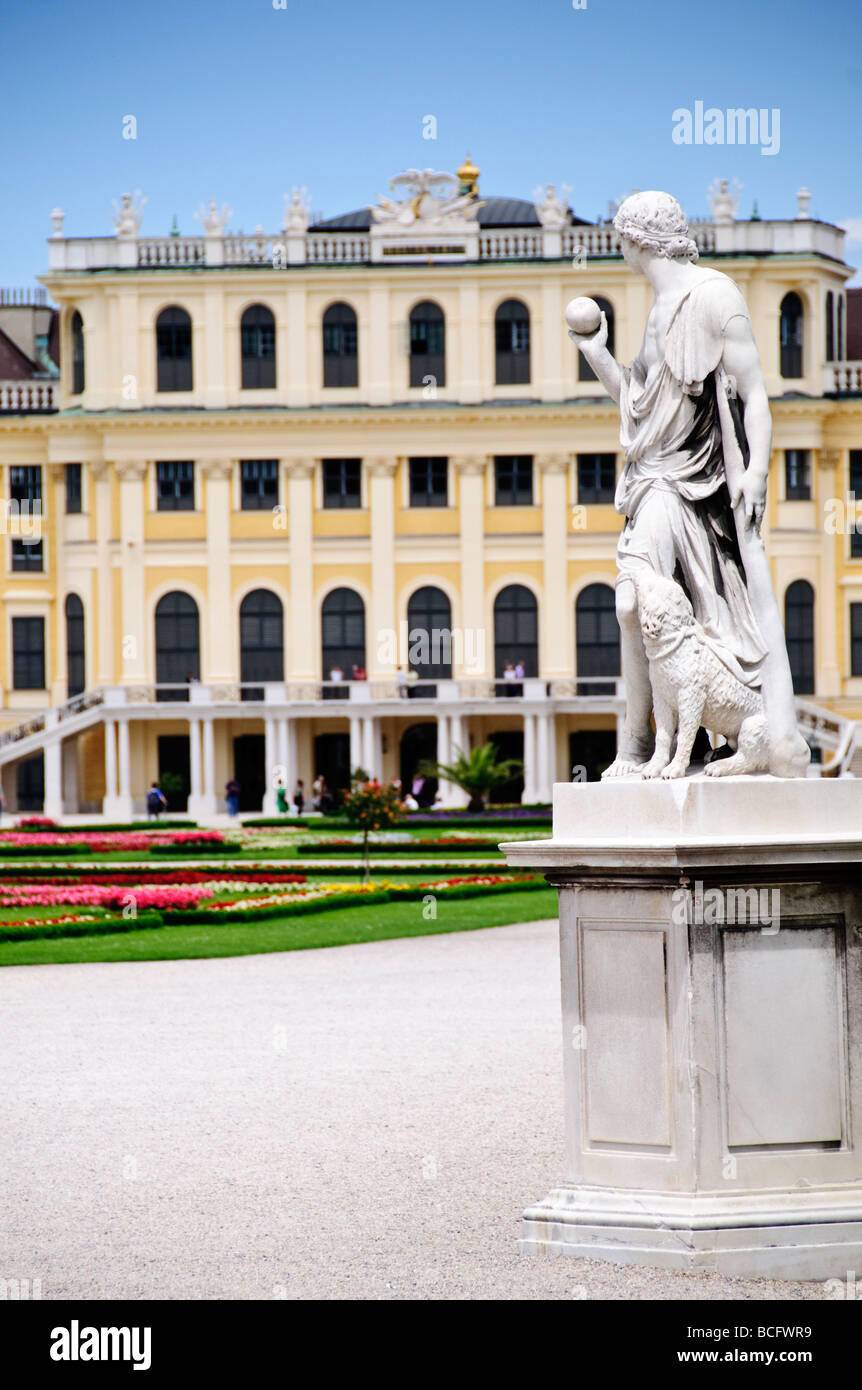 Palazzo Schonbrunn Statua di Artemide nel grande Parterre Vienna Austria | VIENNA, Austria: Una statua in marmo di Artemide, dea della caccia, si affaccia sui giardini del grande Parterre con dietro la facciata ocra del Palazzo Schönbrunn. La figura è una delle 32 statue mitologiche del giardino, la più scolpita dallo scultore Wilhelm Beyer. Il palazzo Rococò con 1.441 camere prese la sua forma attuale sotto l'architetto di corte Nikolaus Pacassi durante il regno dell'imperatrice Maria Teresa, e la tenuta divenne patrimonio dell'umanità dell'UNESCO nel 1996. Foto Stock