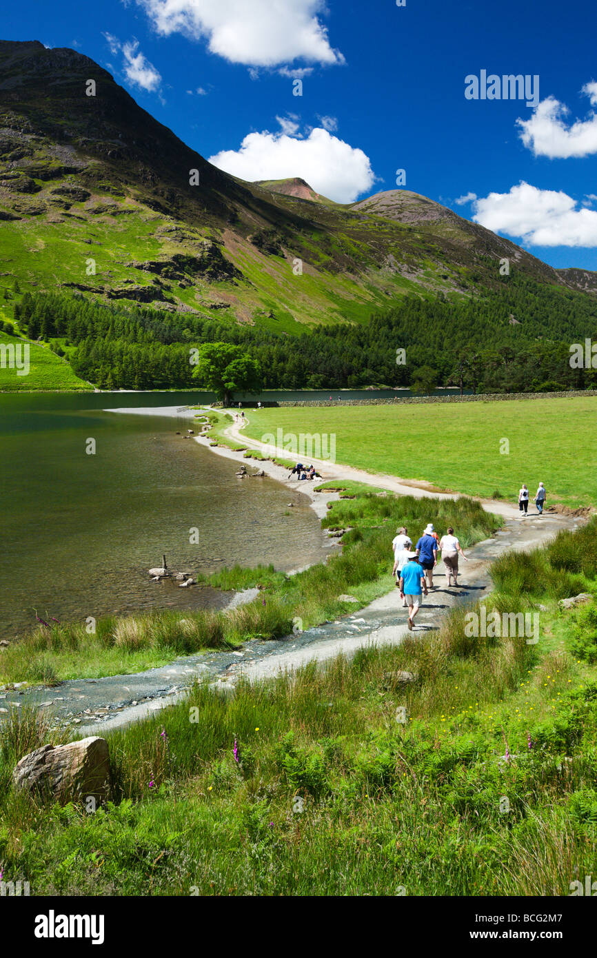 Lago Buttermere Walkers sul sentiero con 'alto stile di montagna di oltre il lago, 'Il Lake District' Cumbria Inghilterra England Regno Unito Foto Stock