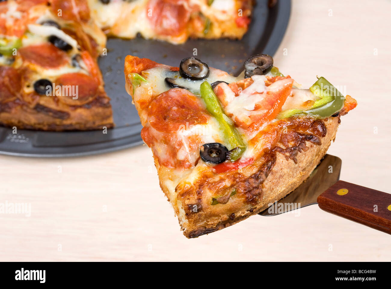 Una fetta delle opere la pizza che viene sollevato dalla vaschetta Foto Stock