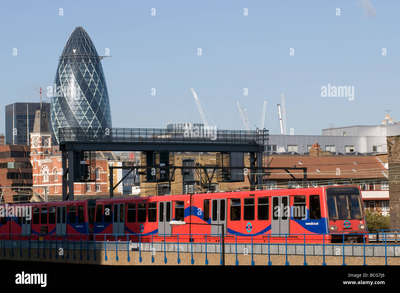Regno Unito. Treni DLR con Swiss Re Building in background in Wapping, East London Foto Julio Etchart Foto Stock