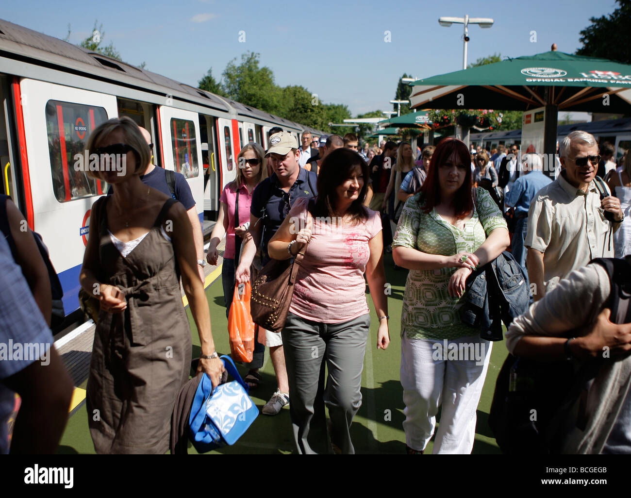 Gli appassionati di tennis di lasciare il treno alla stazione di Southfields per i campionati di Wimbledon Foto Stock