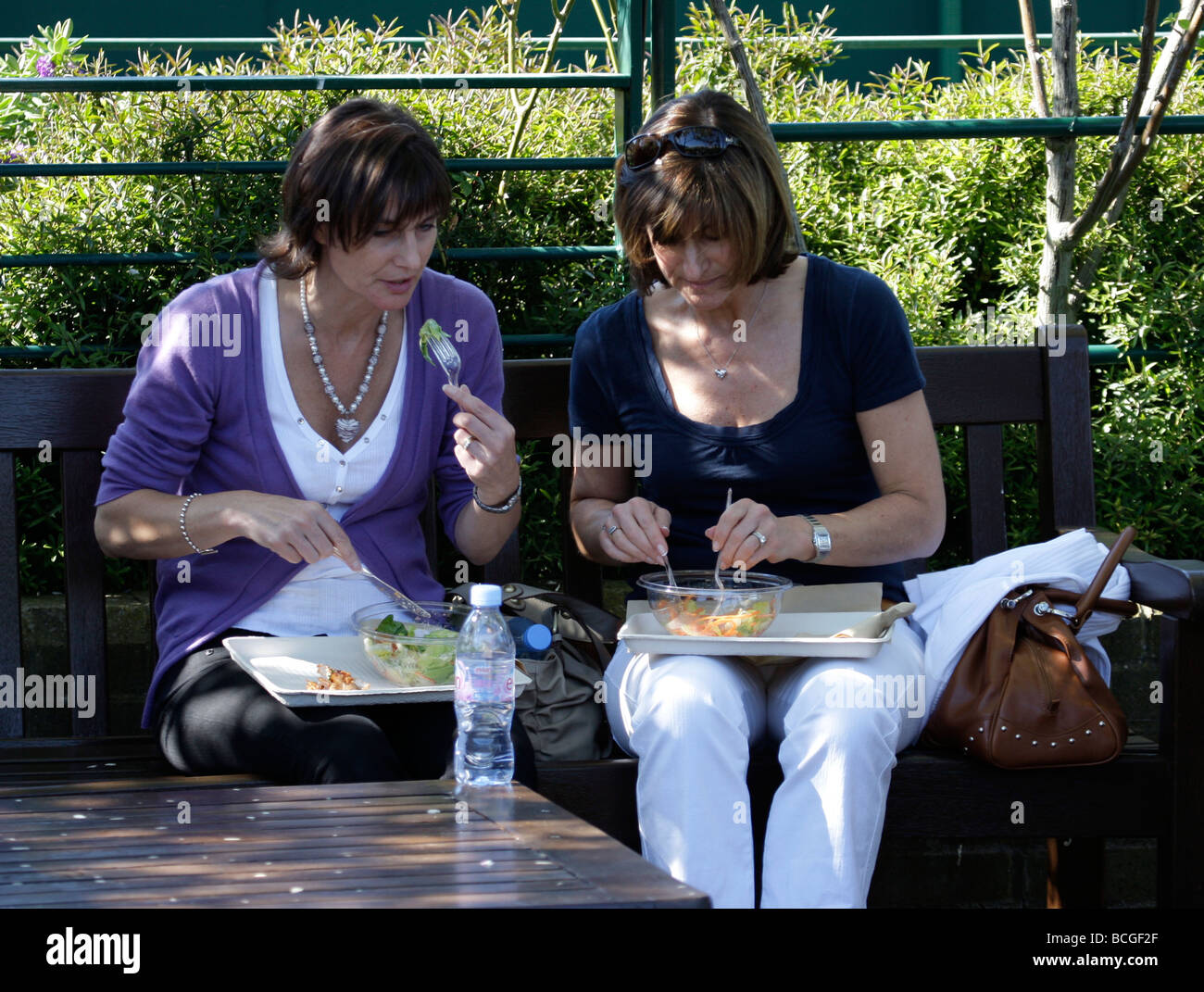 Due donne aventi il pranzo all'ombra a i campionati di Wimbledon 2009 Foto Stock