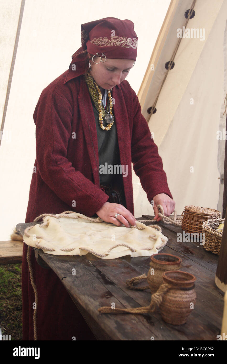Presentazione di una vecchia dimenticata artigiano di professioni. Una donna in abito tradizionale rendendo un tamburo. Ogrodzieniec, Polonia. Foto Stock