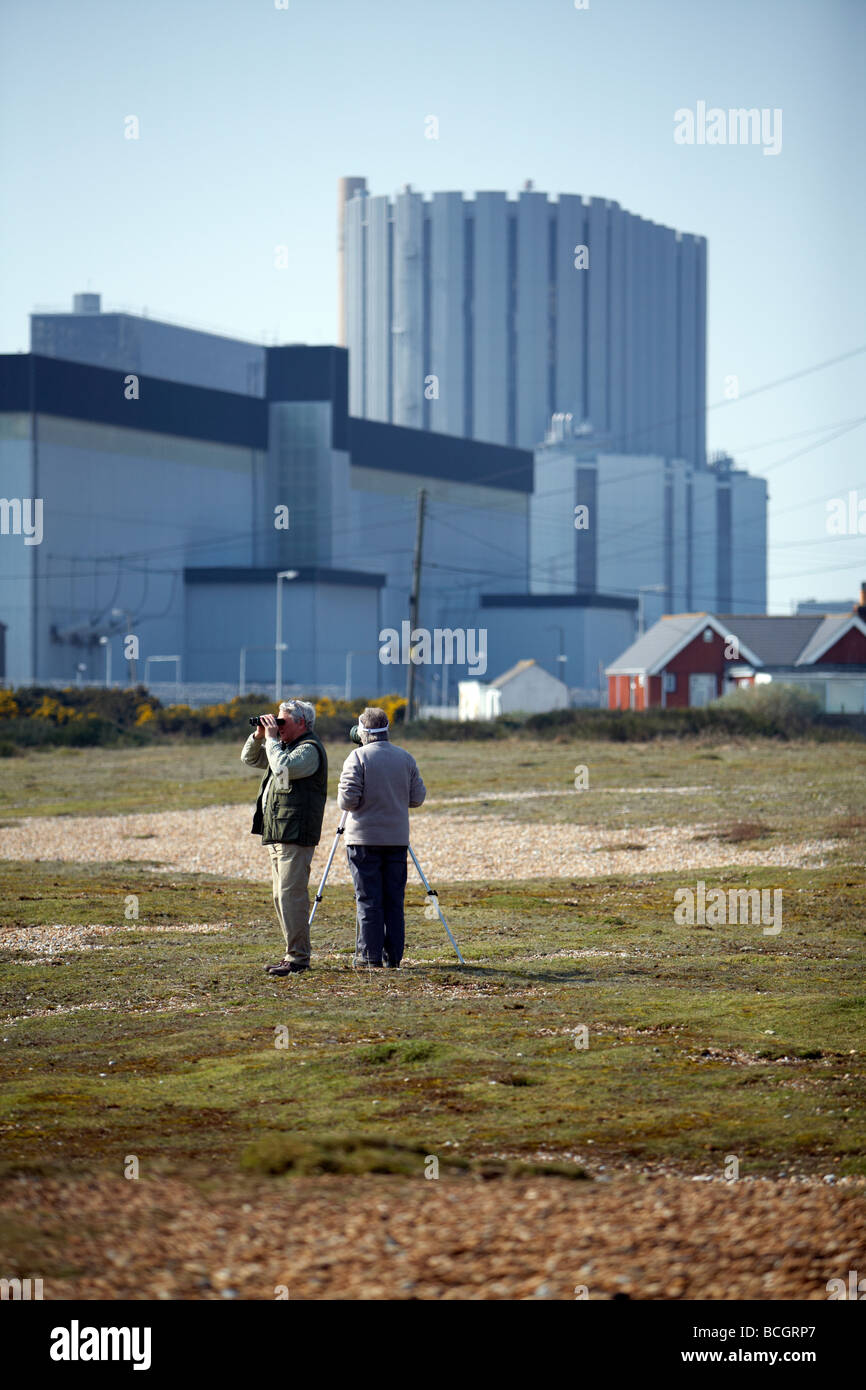 Un paio di guardare gli uccelli nella parte anteriore di Dungeness powerstation nucleare Foto Stock