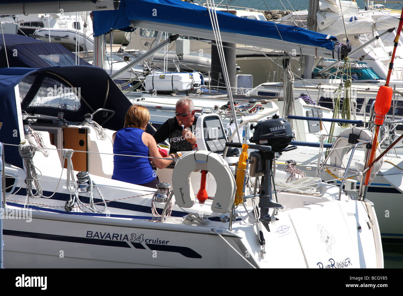 Paio mangiare pasti sulla vela yacht ormeggiati nel porto di Poole, Dorset, Regno Unito Foto Stock