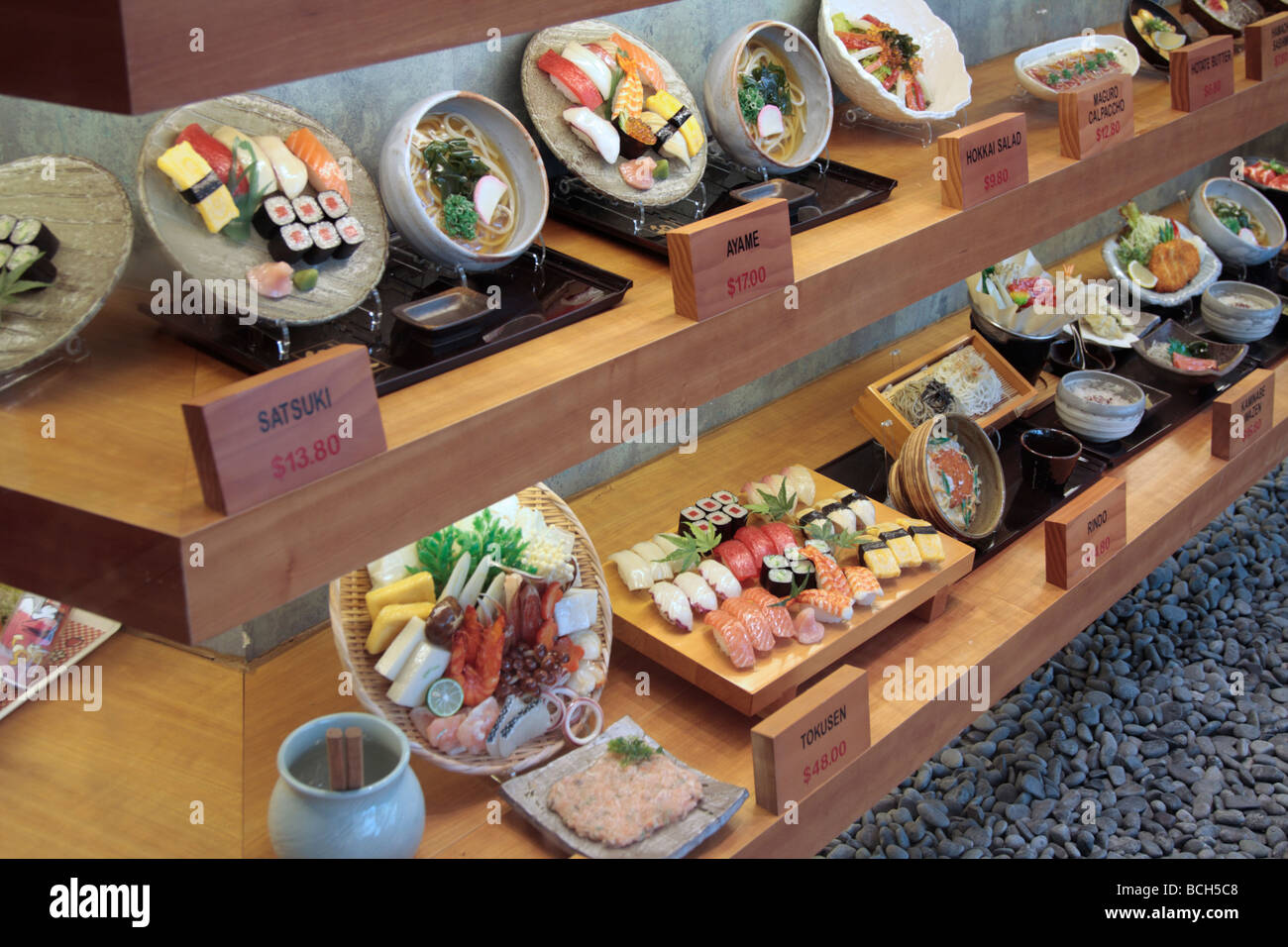 Un display di riproduzioni in plastica del menu disponibile in questo ristorante di sushi in Singapore Foto Stock