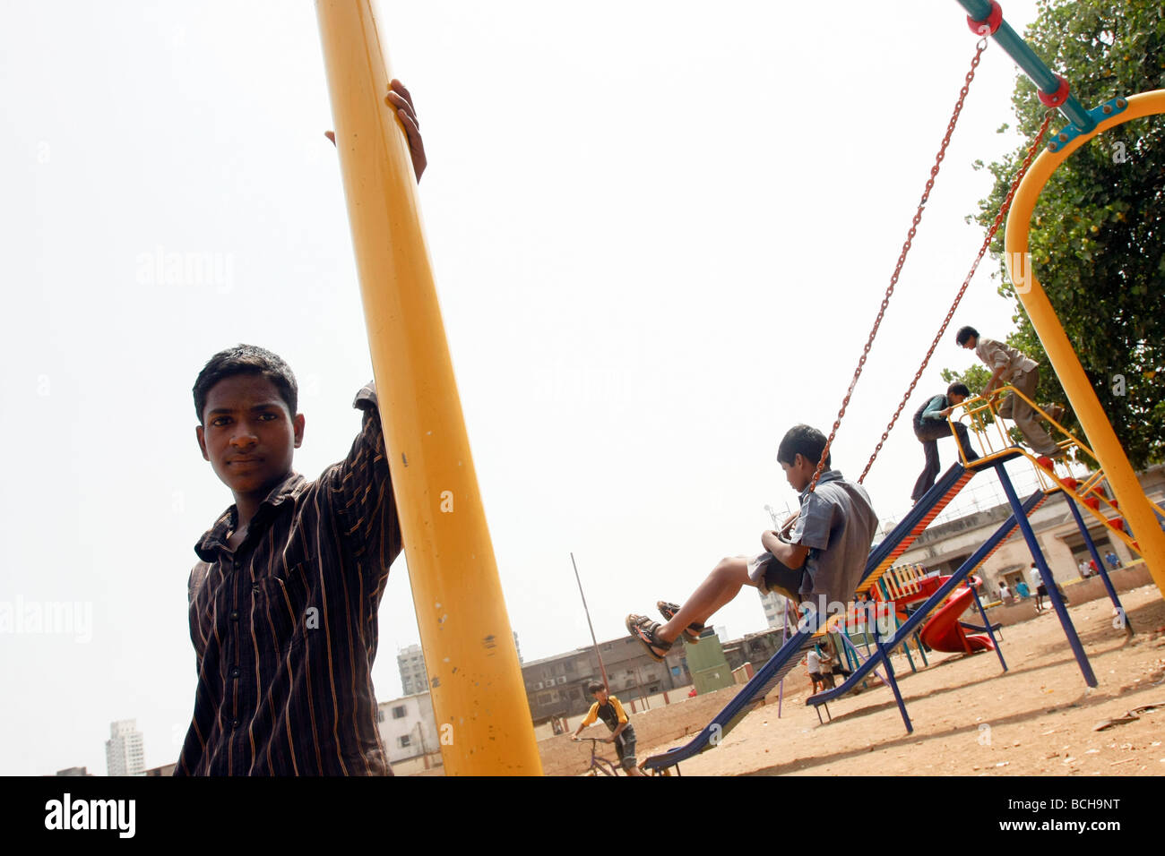I bambini giocano su un set di nuova costruzione oscilla in Dharavi, la più grande delle baraccopoli di Mumbai (Bombay) in India Foto Stock