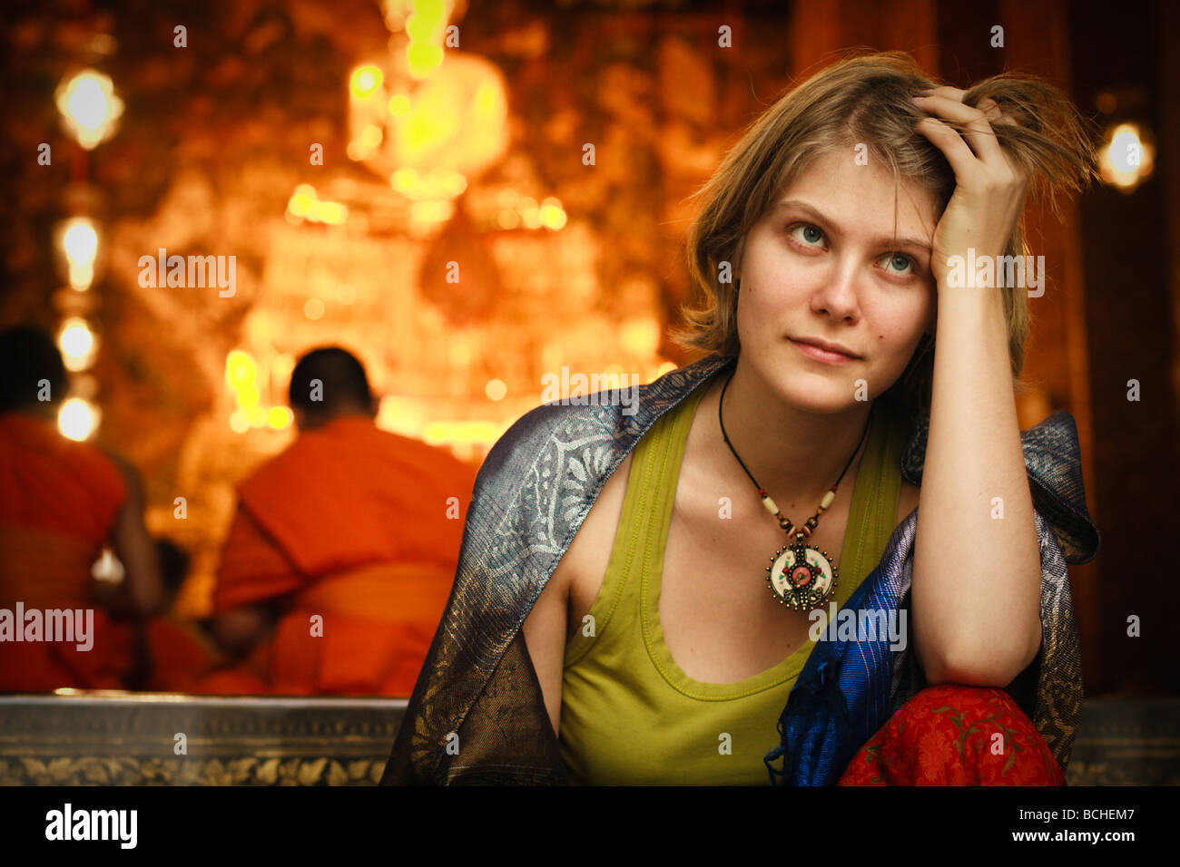 Giovane donna seduta vicino tempio buddhistic Foto Stock