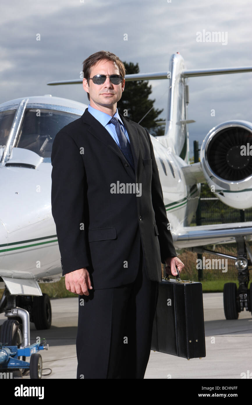 Imprenditore in piedi di fronte a getto aziendale Foto Stock