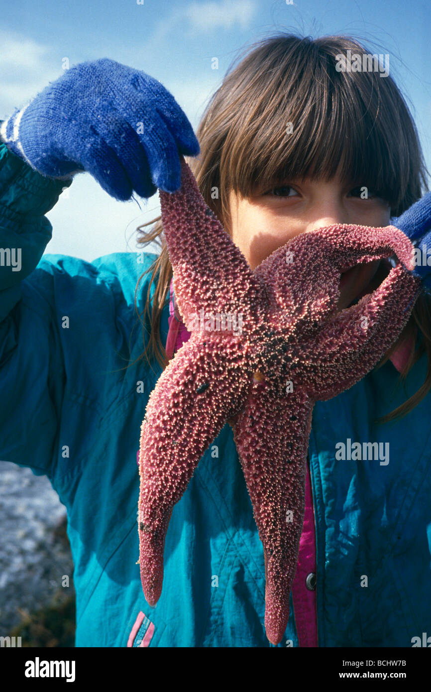 Ragazza giovane trattiene Starfish da Tenticles AK KP MOLLA Foto Stock