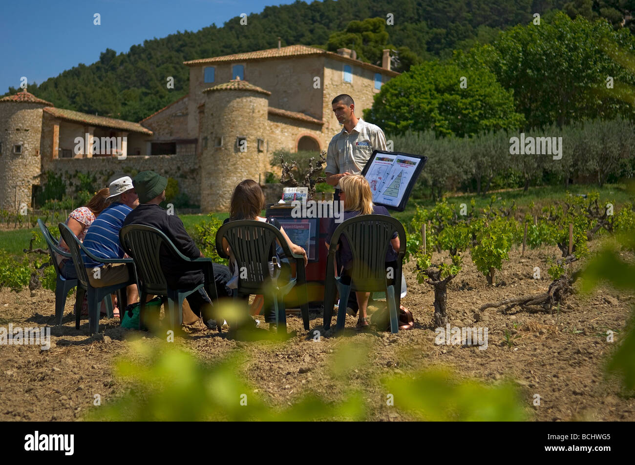 Insediato un gruppo di uomini e donne in un vigneto si ascolta un parlare di vinificazione. Vini Gigondas denominazione. Francia Foto Stock