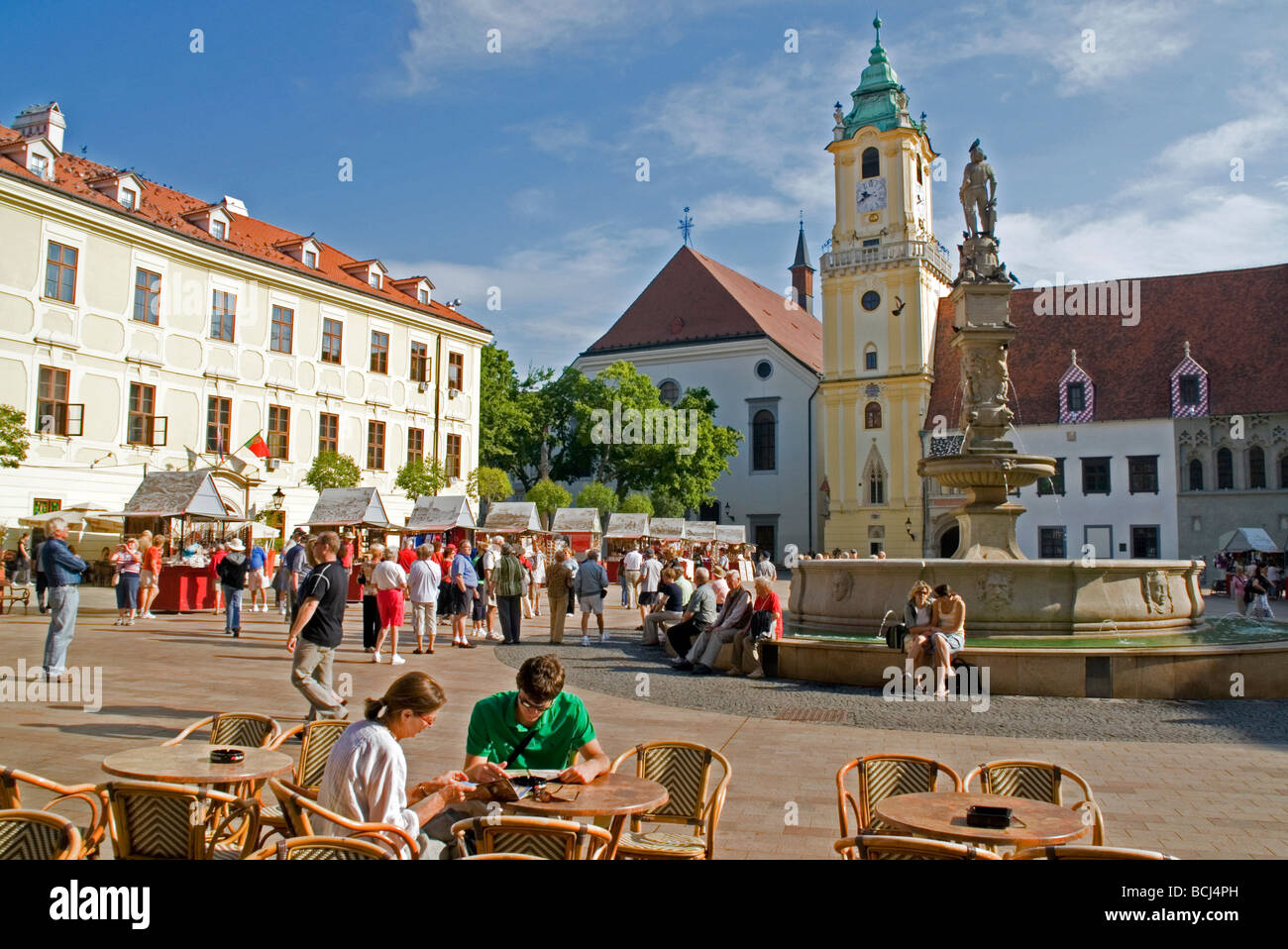 Bratislava's Hlavne Namestie quadrato con il Vecchio Municipio di clock tower e Roland Fontana con la statua di Massimiliano Foto Stock