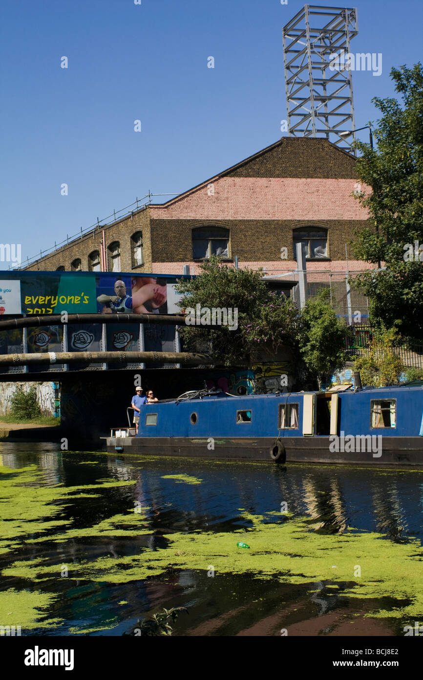 Un paio sul canal boat viaggiando lungo il Fiume Lee di Londra con la pubblicità per Olimpiadi di Londra in background. Foto Stock