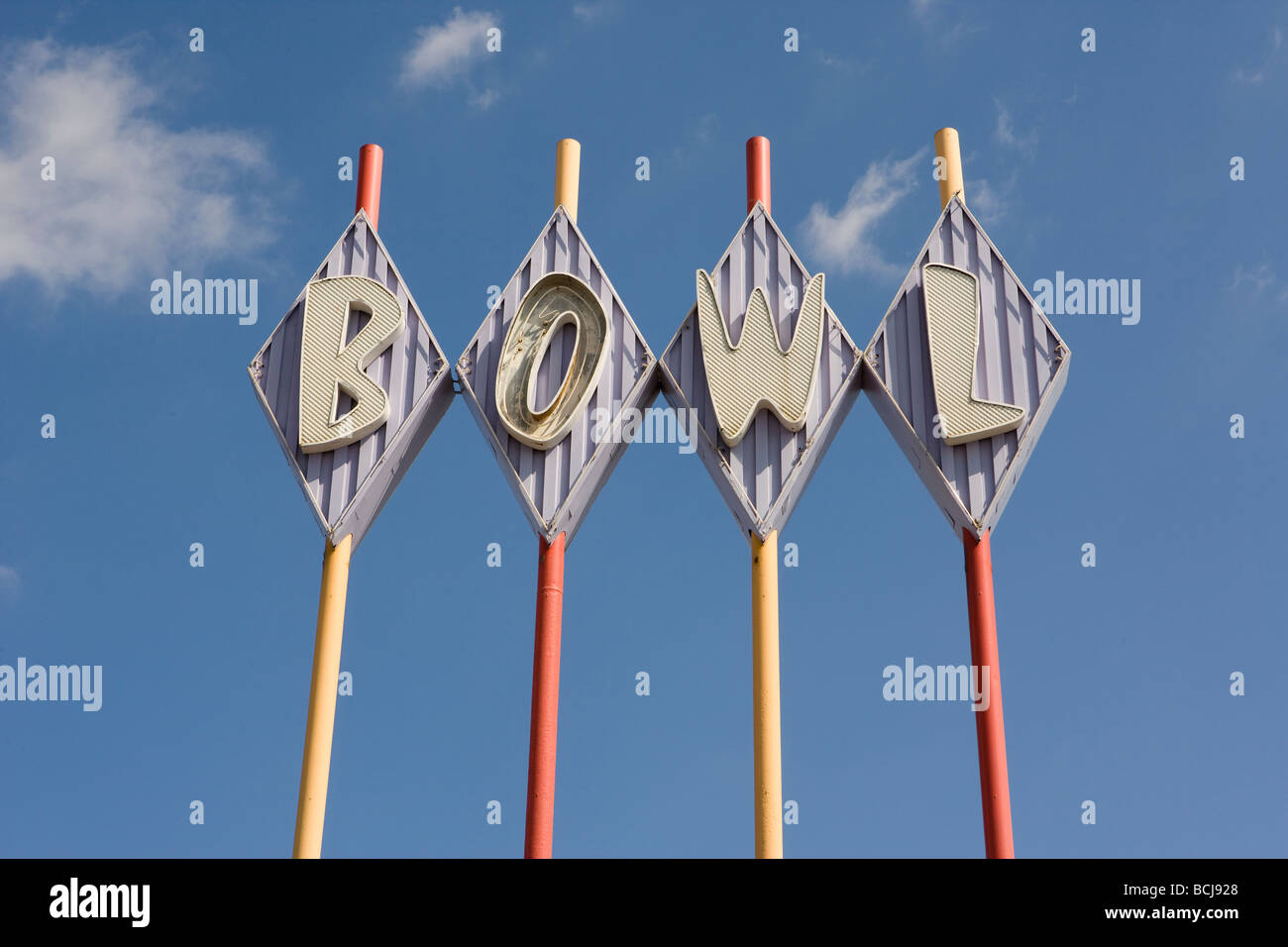 Bowling Alley cartello che dice che la ciotola in rombi Multi poli colorati sullo sfondo del cielo Foto Stock