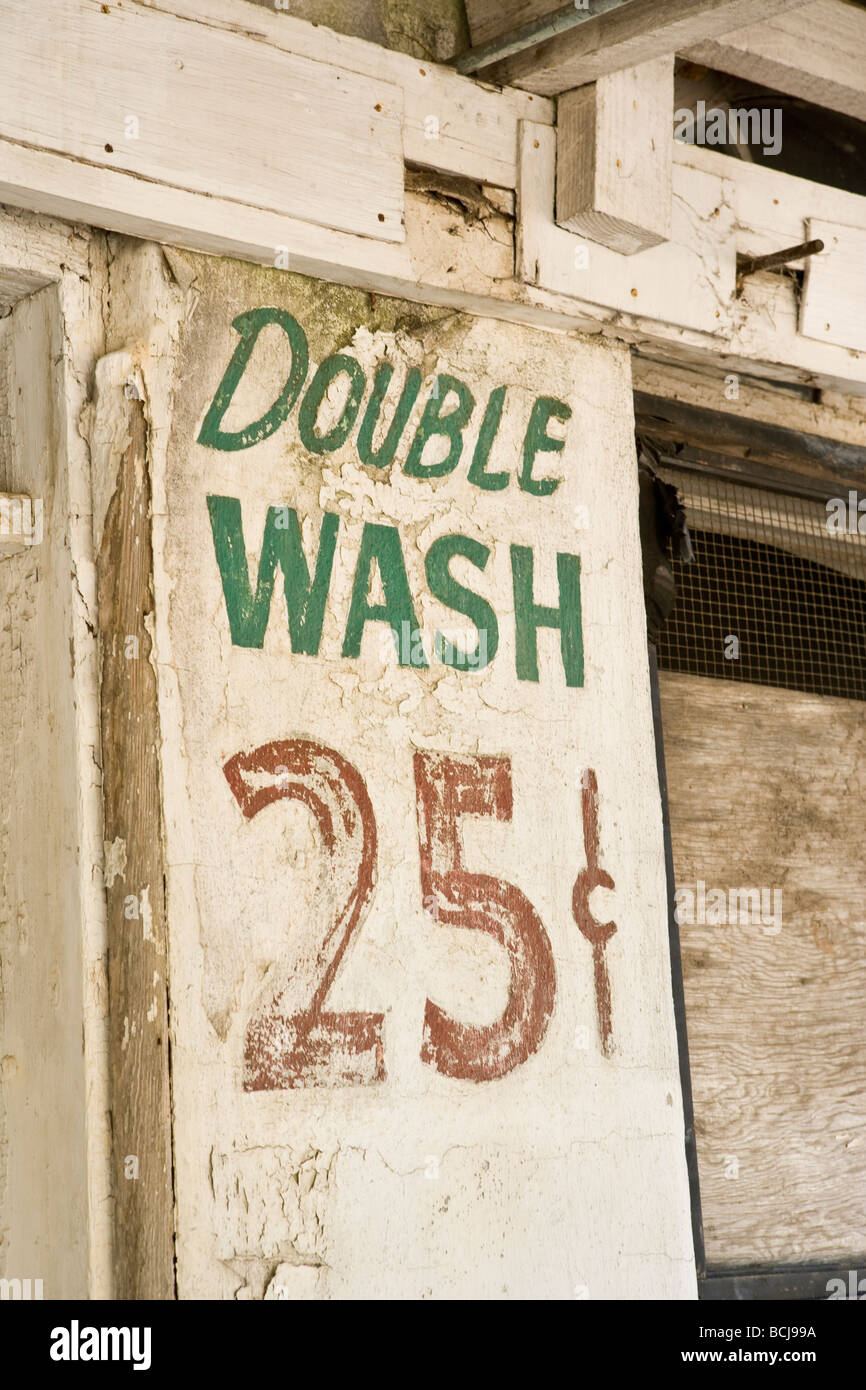 Il vecchio segno dipinto sulla lavanderia a parete edilizia legge doppio 25 di lavaggio Foto Stock
